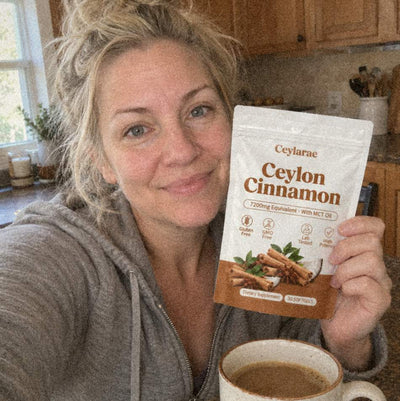 Woman holding a Ceylarae pouch in her kitchen next to a coffee mug