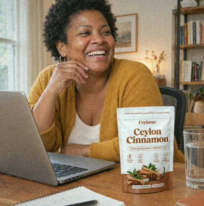Woman laughing at her desk with a Ceylarae pouch next to her laptop
