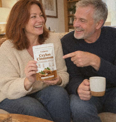 Couple on a sofa laughing, she holds a Ceylarae pouch